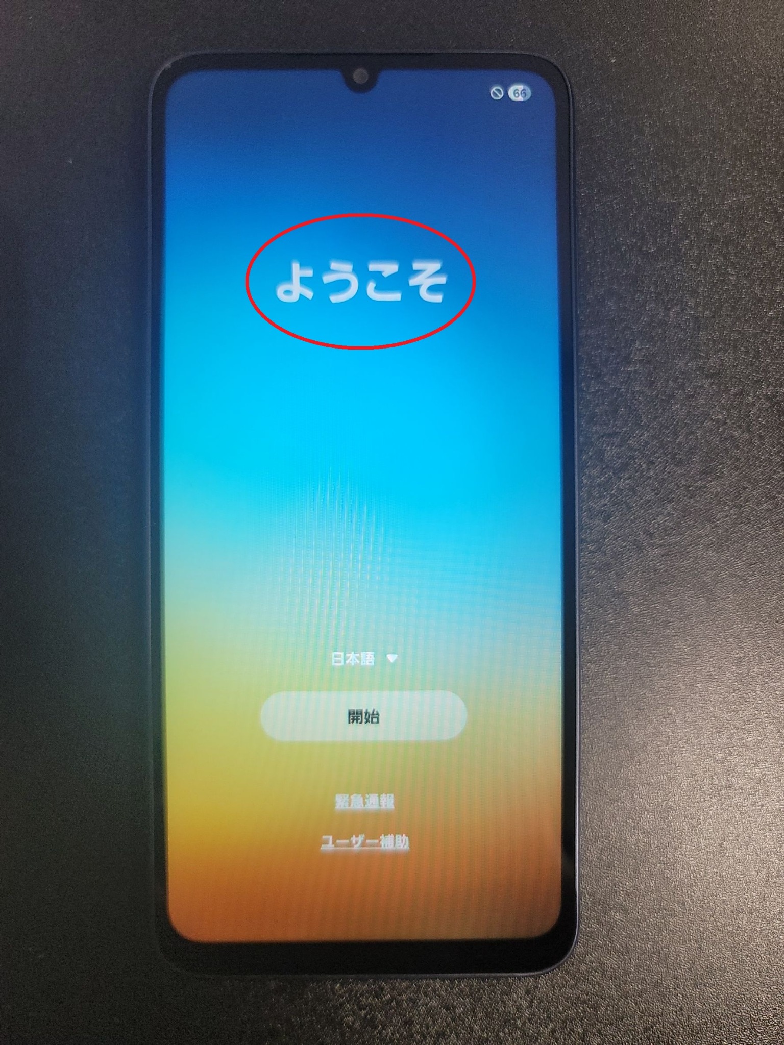 初期設定のようこそ画面。タップする文字部分が赤い丸で示されている